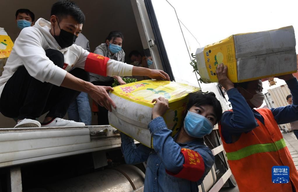 2020年3月3日,在广西南宁国际铁路港,南宁车务段“青年突击队”队员黄莹莹(右二)在搬运广西驰援湖北物资。新华社记者 陆波岸 摄